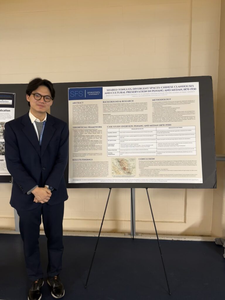 Image conveying Student Research, featuring student Brian Wibowo, in a dark suit and tie stands in front of his poster presentation at a conference at Yale University