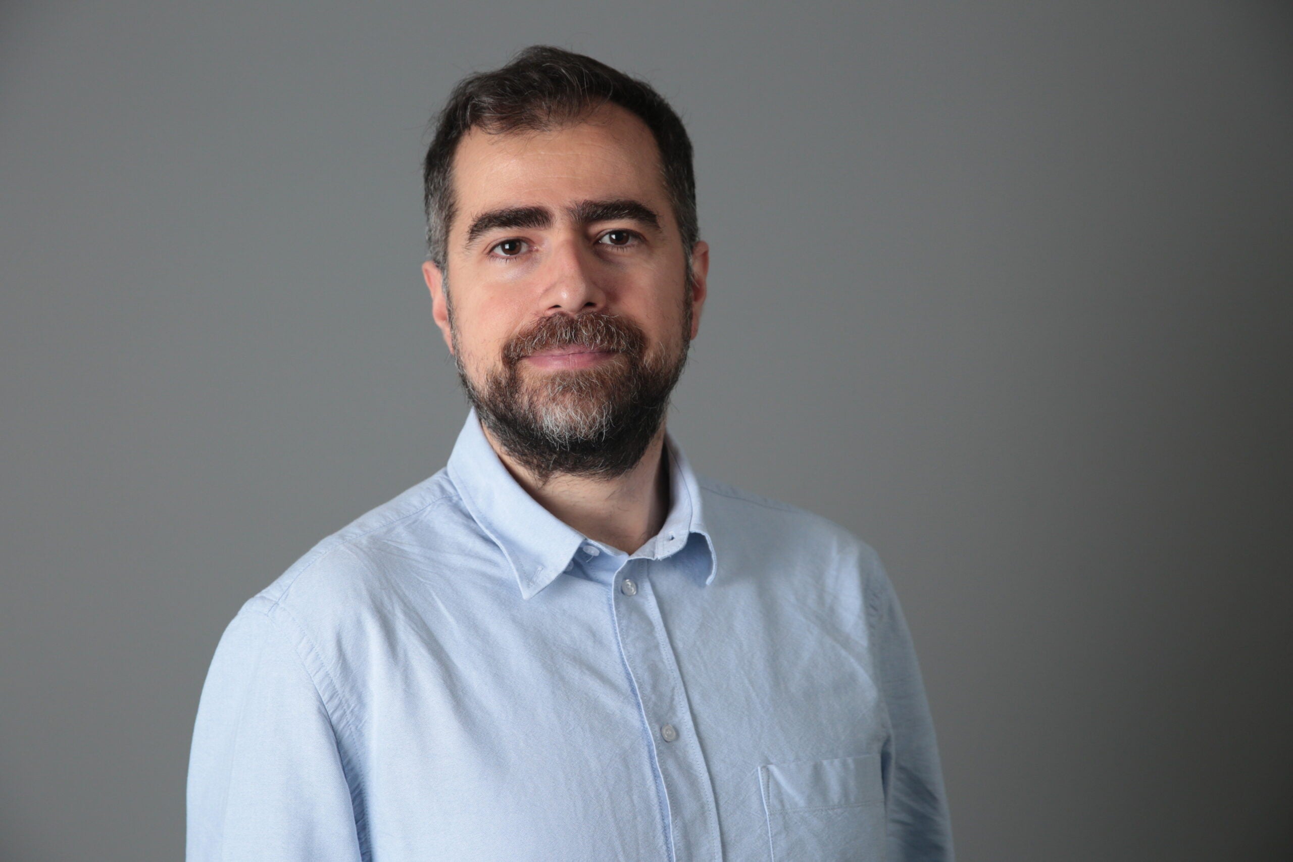 Picture of Mehmet in a light blue collared shirt.