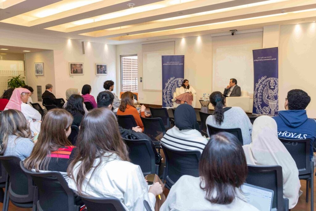 Room full of people with International Lawyer Tamara Essayad talking to Khaled AL-Hroub, Northwestern Qatar
