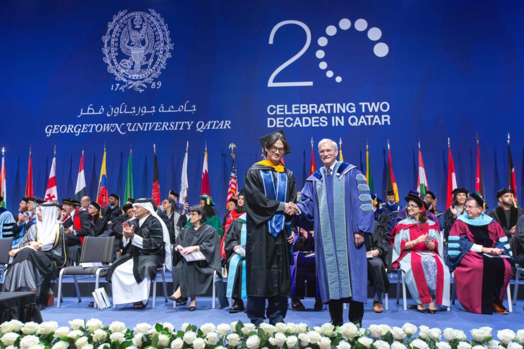 Brian Wibowo shakes hand of Interim President Groves at 2025 Commencement ceremony